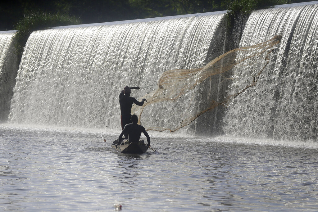 Fishermen cast a net near a dam that sources the sacred Osun River in Esa-Odo, Nigeria, on Saturday, May 28, 2022. (AP Photo/Sunday Alamba)
