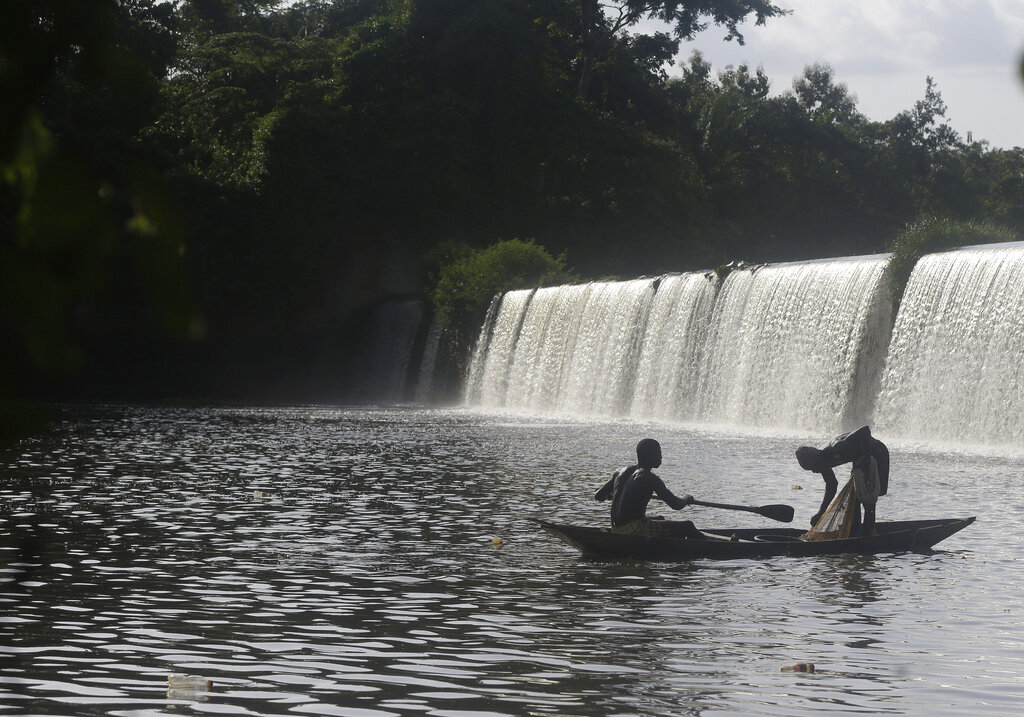 Fishermen paddle their canoe near a dam that sources the sacred river in Esa-Odo Nigeria, on Saturday, May 28, 2022. (AP Photo/Sunday Alamba)
