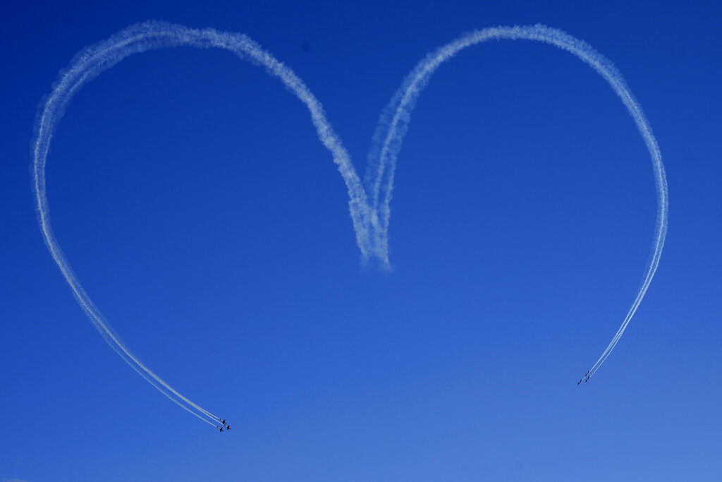 Brazil's aerial demonstration Smoke Squadron creates the shape of a heart in the sky over the Planalto presidential palace during the arrival of the reliquary containing the heart of Brazil's former emperor Dom Pedro I in Brasilia, Brazil, Tuesday, Aug. 23, 2022. The heart arrived from Portugal for display for celebrations of Brazil's independence bicentennial on Sept. 7. (AP Photo/Eraldo Peres)