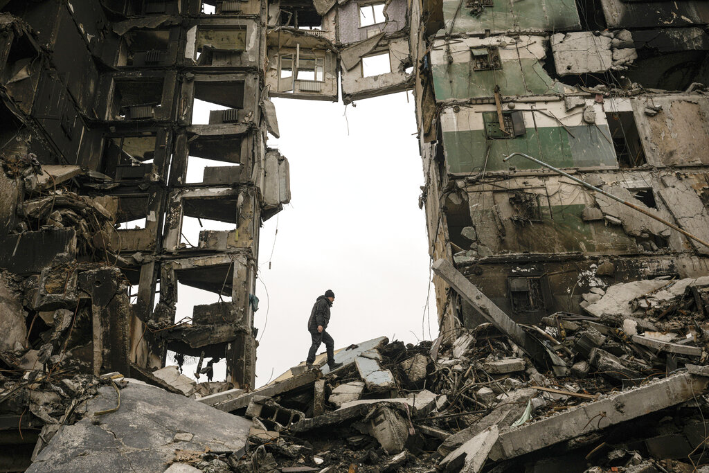 FILE - A resident looks for belongings in an apartment building destroyed during fighting between Ukrainian and Russian forces in Borodyanka, Ukraine, April 5, 2022. Six months ago, Russian President Vladimir Putin sent troops into Ukraine in an unprovoked act of aggression, starting the largest military conflict in Europe since World War II. Putin expected a quick victory but it has turned into a grinding war of attrition. Russian offensive are largely stuck as Ukrainian forces increasingly target key facilities far behind the front lines. (AP Photo/Vadim Ghirda, File)
