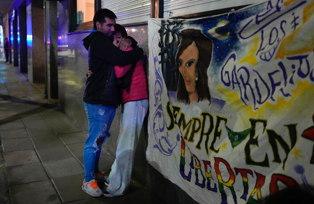 A couple who witnessed when a man pointed a gun at Argentina's Vice President Cristina Fernandez during an event in front of her home in the Recoleta neighborhood of Buenos Aires, Argentina, comfort each other, Thursday, Sept. 1, 2022. (AP Photo/Natacha Pisarenko)