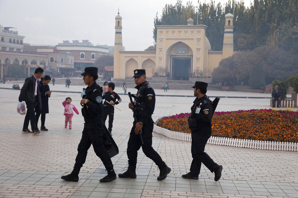 FILE - Uyghur security personnel patrol near the Id Kah Mosque in Kashgar in western China's Xinjiang region, Nov. 4, 2017. China's discriminatory detention of Uyghurs and other mostly Muslim ethnic groups in the western region of Xinjiang may constitute crimes against humanity, the U.N. human rights office said in a long-awaited report Wednesday, Aug. 31, 2022, which cited 