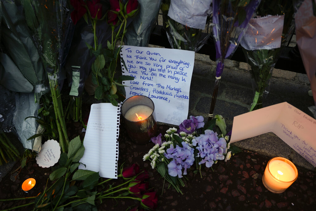 Messages, flowers and candles are seen at the gates of Buckingham Palace in London, Friday, Sept. 9, 2022. Queen Elizabeth II, Britain's longest-reigning monarch and a rock of stability across much of a turbulent century, died Thursday Sept. 8, 2022, after 70 years on the throne. She was 96. (AP Photo/Kirsty Wigglesworth)