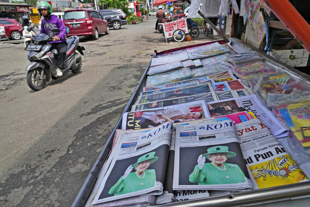 Newspapers fronting pictures of Queen Elizabeth II are displayed on a newsstand following her passing, in Jakarta, Indonesia, Friday, Sept. 9, 2022. Queen Elizabeth II, Britain's longest-reigning monarch, died Thursday after 70 years on the throne. She was 96. (AP Photo/Tatan Syuflana)