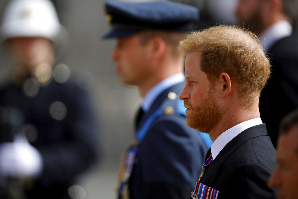 Britain's Prince Harry, right, and Prince William attend the procession for Queen Elizabeth II following her funeral service in Westminster Abbey in central London, Monday, Sept. 19, 2022. The Queen, who died aged 96 on Sept. 8, will be buried at Windsor alongside her late husband, Prince Philip, who died last year. (Sarah Meyssonnier/Pool Photo via AP)