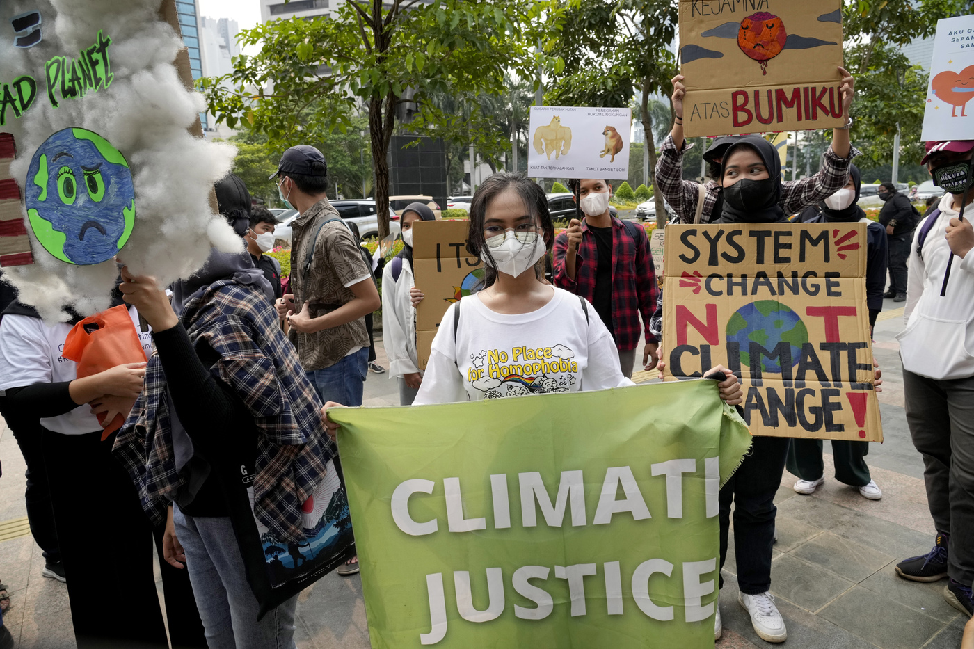 Environmental activists hold up posters during a protest calling for the government to take immediate action against climate change in Jakarta, Indonesia, Friday, March 25, 2022. (AP Photo/Tatan Syuflana)