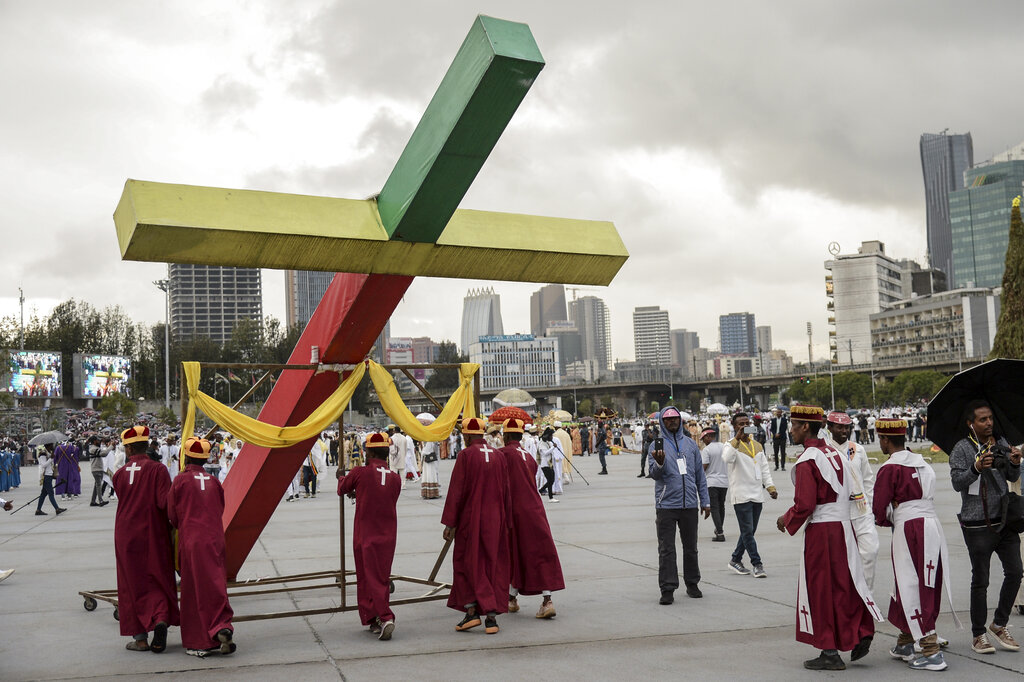 Ethiopian Orthodox Christians carry a large crucifix painted in traditional colors to celebrate the eve of the holiday of Meskel in Addis Ababa, Ethiopia Monday, Sept. 26, 2022. The festival commemorates the unearthing of the 