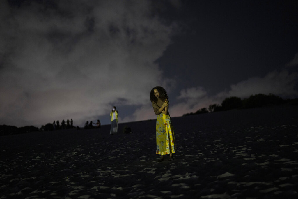 A woman prays in an area of the Abaete dune system, on a steep rise of sand evangelicals have come to call the 