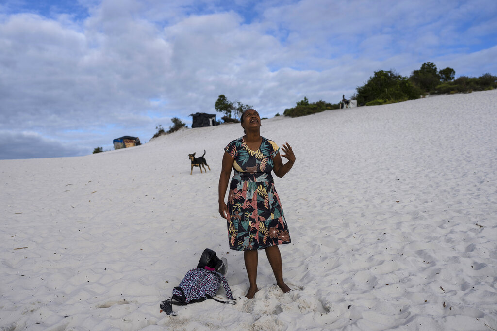 A woman prays in an area of the Abaete dune system, on a steep rise of sand evangelicals have come to call the 