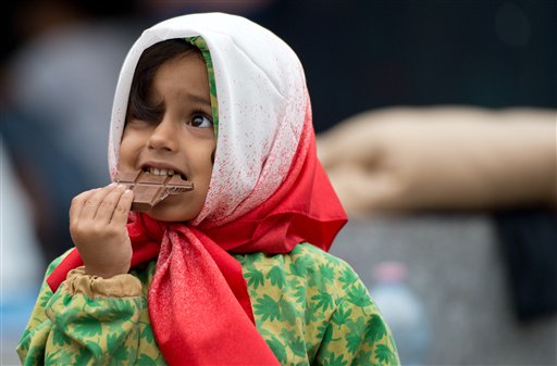 Una bambina siriana riceve cioccolata all'arrivo in Germania. Il Paese accoglie i rifugiati siriani