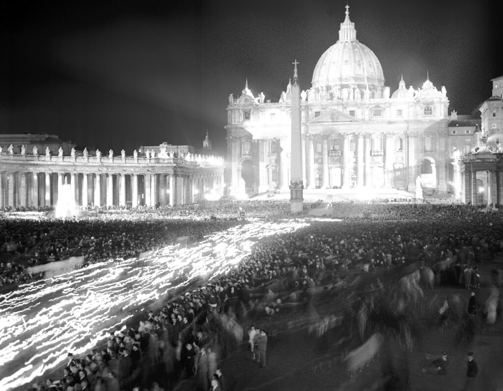 Thousands of faithful Catholics carry torches in a big procession in St. Peter's Square the evening of Oct. 11, 1962, while thousands of onlookers stood by, all waiting for Pope John XXIII to appear at the window of his private apartment in the Vatican Palace, and impart his blessing upon them. Pope Francis commemorates the 60th anniversary of the opening of the Second Vatican Council by celebrating a Mass in honor of St. John XXIII, the “good pope” who convened the landmark meetings that modernized the Catholic Church. (AP Photo/Girolamo Di Majo, File)