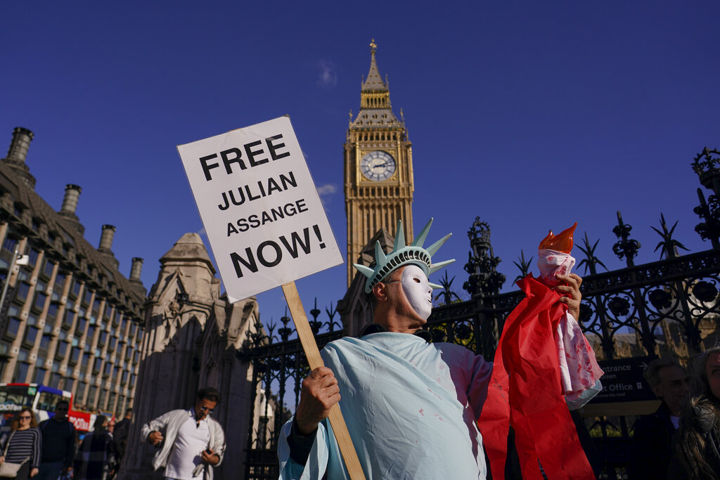 A person holds a placard in support of Julian Assange, against his extradition to the US, in London, Saturday, Oct. 8, 2022. Demonstrators made a human chain around Parliament, to support WikiLeaks founder Julian Assange who is detained in Belmarsh Prison, after he has battled in British courts for years to avoid being sent to the U.S., where he faces 17 charges of espionage and one charge of computer misuse. (AP Photo/Alberto Pezzali)