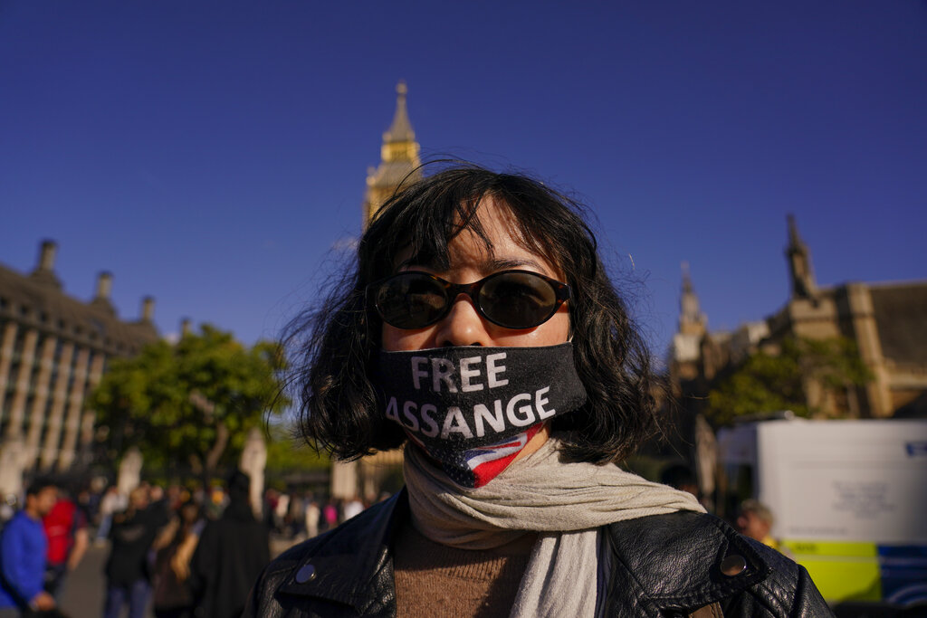 A woman wears a face mask in support of Julian Assange, against his extradition to the US, in London, Saturday, Oct. 8, 2022. Demonstrators made a human chain around Parliament, to support WikiLeaks founder Julian Assange who is detained in Belmarsh Prison, after he has battled in British courts for years to avoid being sent to the U.S., where he faces 17 charges of espionage and one charge of computer misuse. (AP Photo/Alberto Pezzali)