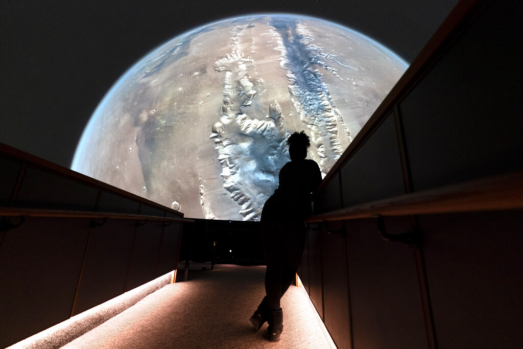 A staffer looks at a scene of Mars from the planetarium film, 
