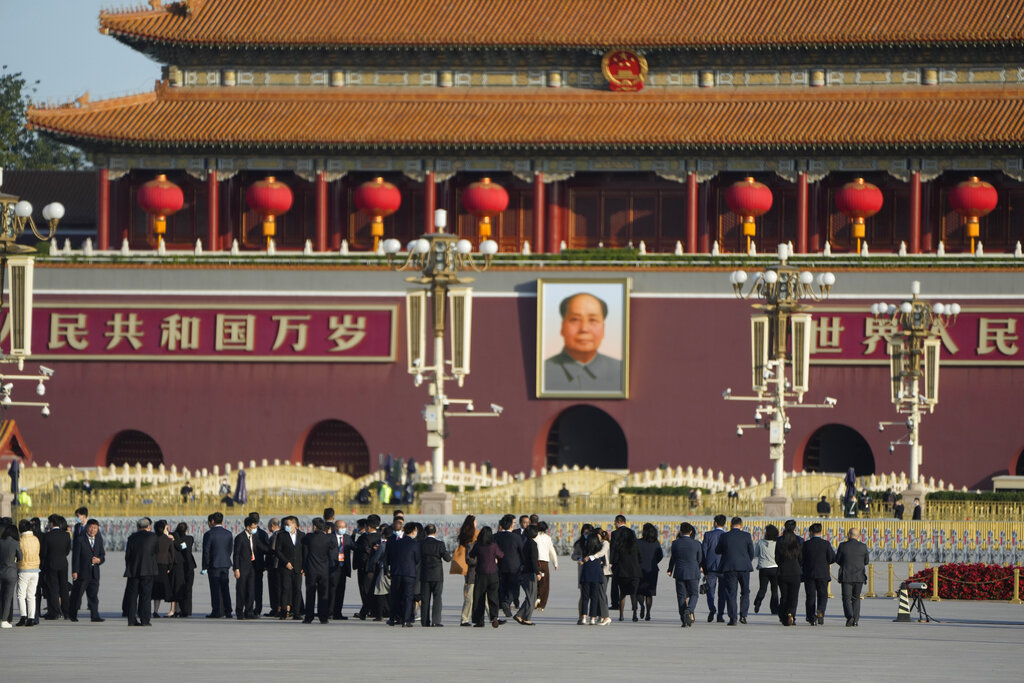 Attendees walk on Tiananmen Square near the Great Hall of the People where the opening ceremony for the 20th National Congress of China's ruling Communist Party will be held in Beijing, China, Sunday, Oct. 16, 2022. China on Sunday opens a twice-a-decade party conference at which leader Xi Jinping is expected to receive a third five-year term that breaks with recent precedent and establishes himself as arguably the most powerful Chinese politician since Mao Zedong. (AP Photo/Mark Schiefelbein)