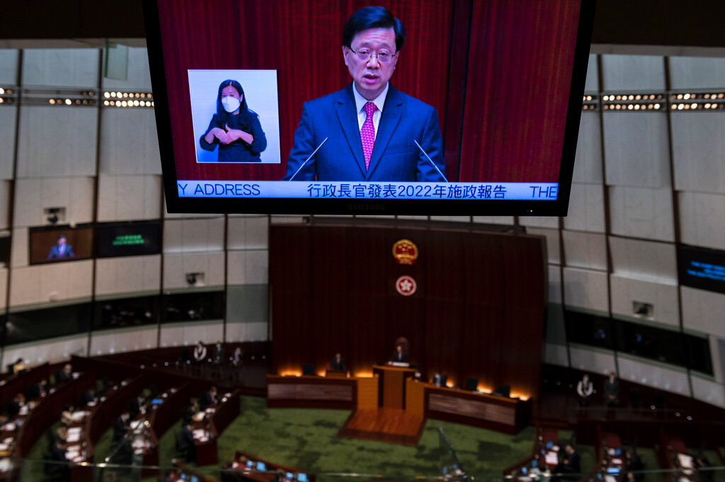 A video screen shows Hong Kong Chief Executive John Lee as he delivers his policy address at the chamber of the Legislative Council in Hong Kong, Wednesday, Oct. 19, 2022. Hong Kong's leader on Wednesday unveiled a new visa scheme to woo global talent, as the city seeks to stem a brain drain that has risked its status as an international financial center. (AP Photo/Vernon Yuen)