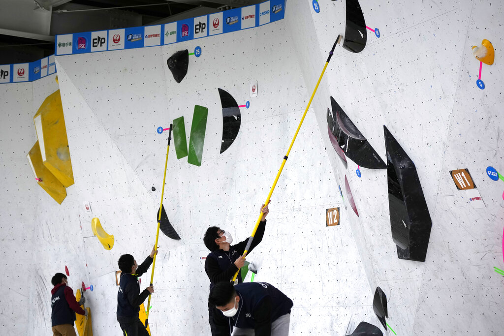 Staff clean the wall stones during the women's and men's boulder semi-final of IFSC Climbing World Cup Friday, Oct. 21, 2022, in Morioka, Iwate Prefecture, Japan. After Iranian climber Elnaz Rekabi joined a growing list of female athletes who have been targeted by their governments for defying authoritarian policies or acting out against bullying, a number of others have spoken out on their concerns of politics crossing into their sporting world. (AP Photo/Eugene Hoshiko)