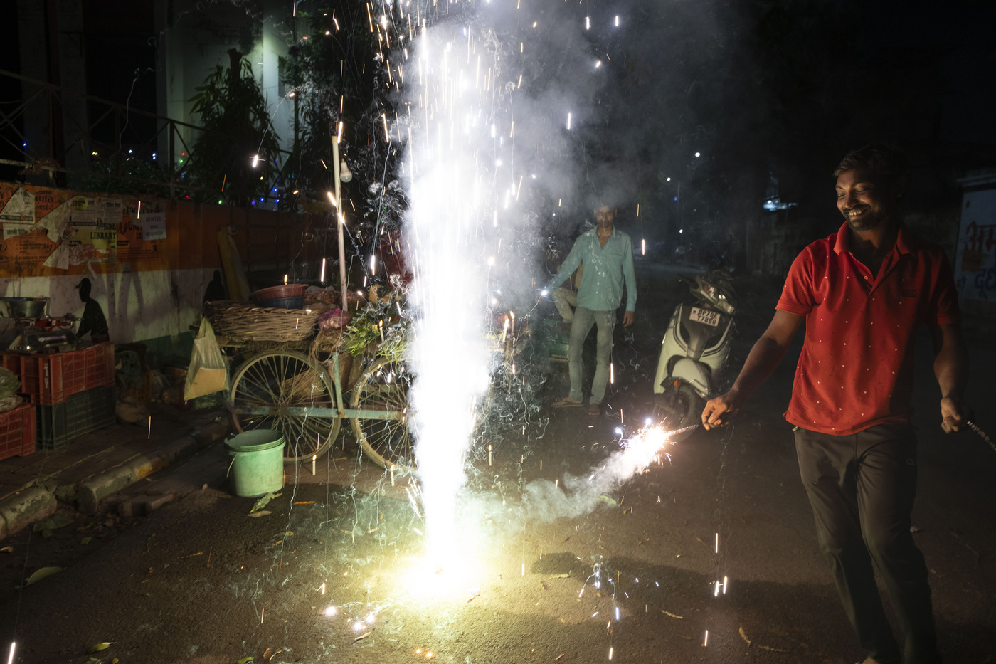 An Indian vegetable vendor lights firecrackers to celebrate Diwali, the Hindu festival of lights, in Prayagraj, in the northern state of Uttar Pradesh, India, Monday, Oct. 24, 2022. Indians across the country are celebrating Diwali, the Hindu festival that symbolizes the victory of light over darkness. (AP Photo/Rajesh Kumar Singh)