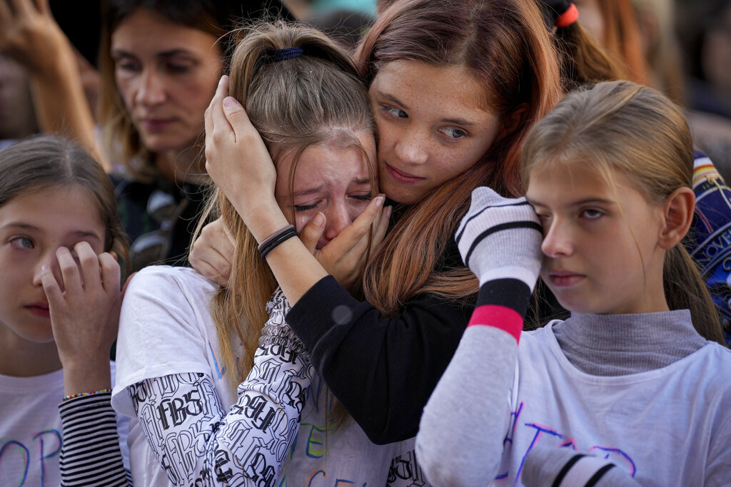 Participants cry while listening to a speech by a victim of domestic violence during a protest aiming to raise awareness to the violence and prejudice against women in Romanian society in Bucharest, Romania, Sunday, Oct. 23, 2022. Participants called for better support and protection for the victims of violence and the implementation of a national strategy to ensure gender equality and combat domestic violence. (AP Photo/Andreea Alexandru)