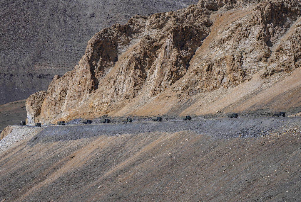 Indian army vehicles move in a convoy in the cold desert region of Ladakh, India, Sunday, Sept. 18, 2022. The ongoing military standoff between India and China has witnessed deployment of tens of thousands of additional soldiers to the already militarized region and has led to massive infrastructure development in recent years. (AP Photo/Mukhtar Khan)