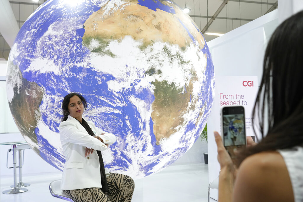 A woman poses for photos at the COP27 U.N. Climate Summit, Monday, Nov. 7, 2022, in Sharm el-Sheikh, Egypt. (AP Photo/Peter Dejong)