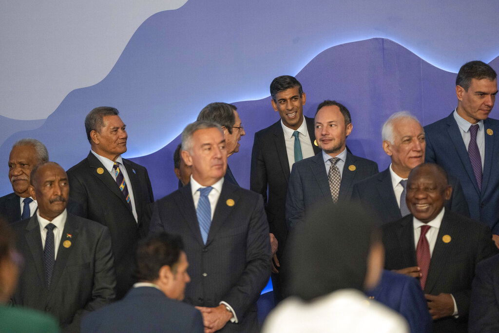 Britain's Prime Minister Rishi Sunak, back center, waits with leaders for a group photo at the COP27 U.N. Climate Summit, in Sharm el-Sheikh, Egypt, Monday, Nov. 7, 2022. (AP Photo/Nariman El-Mofty)