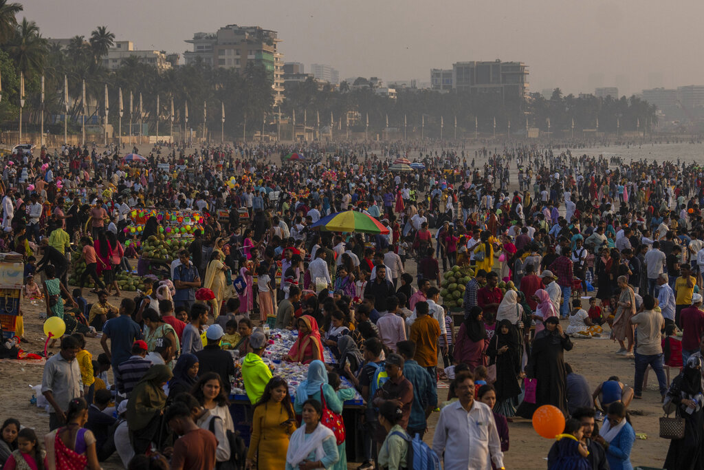 People crowd the Juhu beach on the Arabian Sea coast in Mumbai, India, Sunday, Nov. 13, 2022. The world's population is projected to hit an estimated 8 billion people on Tuesday, Nov. 15, according to a United Nations projection. (AP Photo/Rafiq Maqbool)