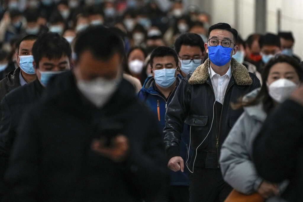 Commuters wearing face masks walk rush to catch their trains at a subway station during the morning rush hour in Beijing on Monday, Nov. 14, 2022. The world's population is projected to hit an estimated 8 billion people on Tuesday, Nov. 15, according to a United Nations projection. (AP Photo/Andy Wong)