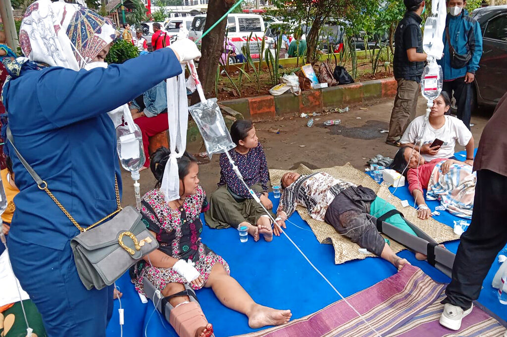 People injured during an earthquake receive medical treatment in a hospital parking lot in Cianjur, West Java, Indonesia, Monday, Nov. 21, 2022. An earthquake shook Indonesia's main island of Java on Monday damaging dozens of buildings and sending residents into the capital's streets for safety. (AP Photo/Firman Taqur)