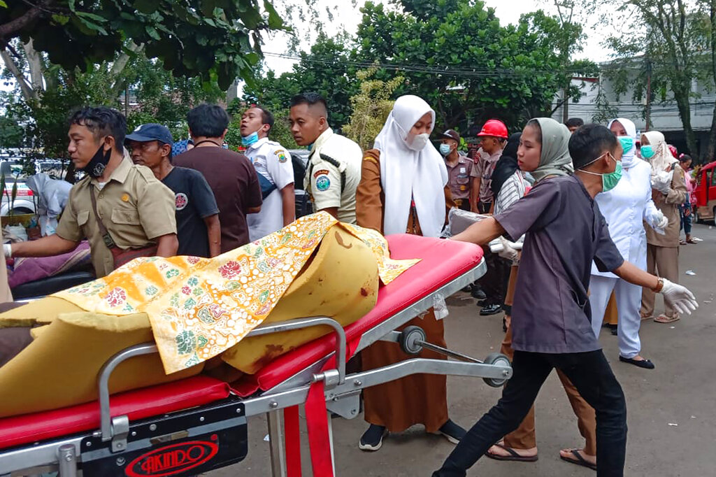 A hospital worker carries an earthquake victim on a gurney outside a hospital in Cianjur, West Java, Indonesia, Monday, Nov. 21, 2022. An earthquake shook Indonesia’s main island of Java on Monday, killing number of people, damaging dozens of buildings and sending residents into the capital's streets for safety. (AP Photo/Firman Taqur)