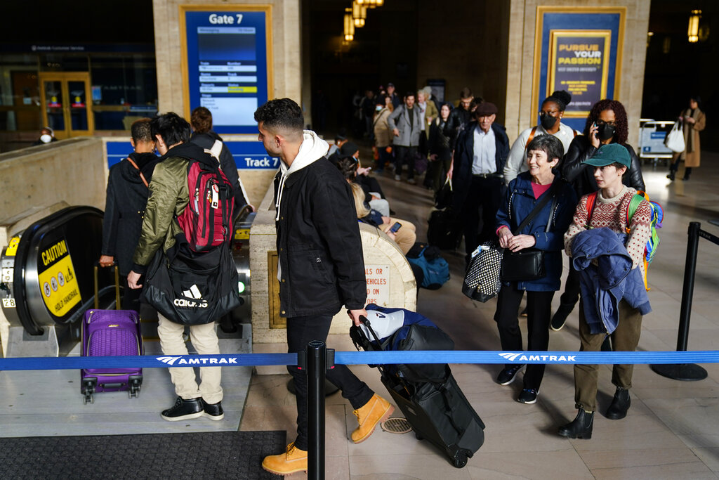 Travelers wait in line to board an Amtrak train ahead of the Thanksgiving Day holiday at 30th Street Station in Philadelphia, Wednesday, Nov. 23, 2022. (AP Photo/Matt Rourke)