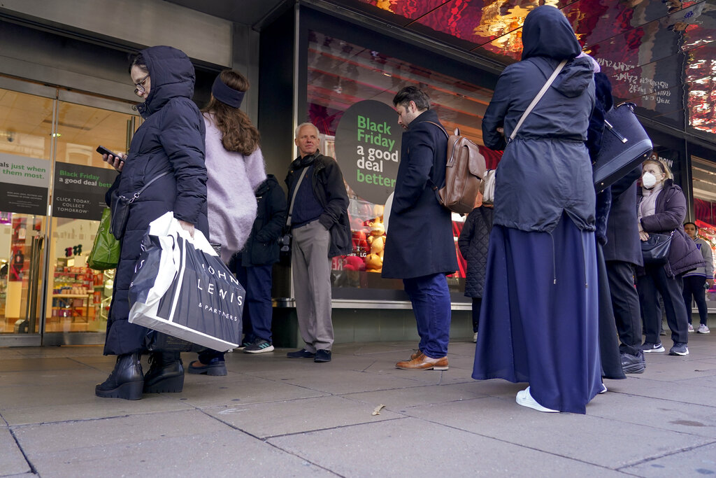 People queue outside a retail shop in Oxford Street on Black Friday, in London, Friday, Nov. 25, 2022. (AP Photo/Alberto Pezzali)