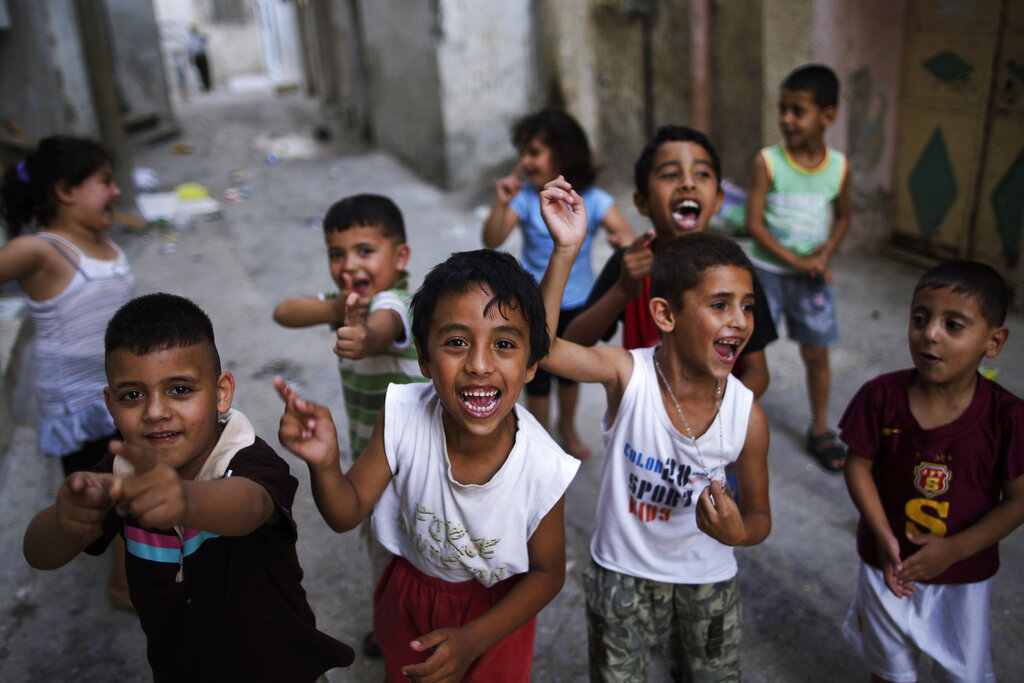 Palestinian children react in front of the camera as the play in an alley of Al-Amari refugee camp in the West Bank city of Ramallah, Monday, Aug. 2, 2010. (AP Photo/Muhammed Muheisen)