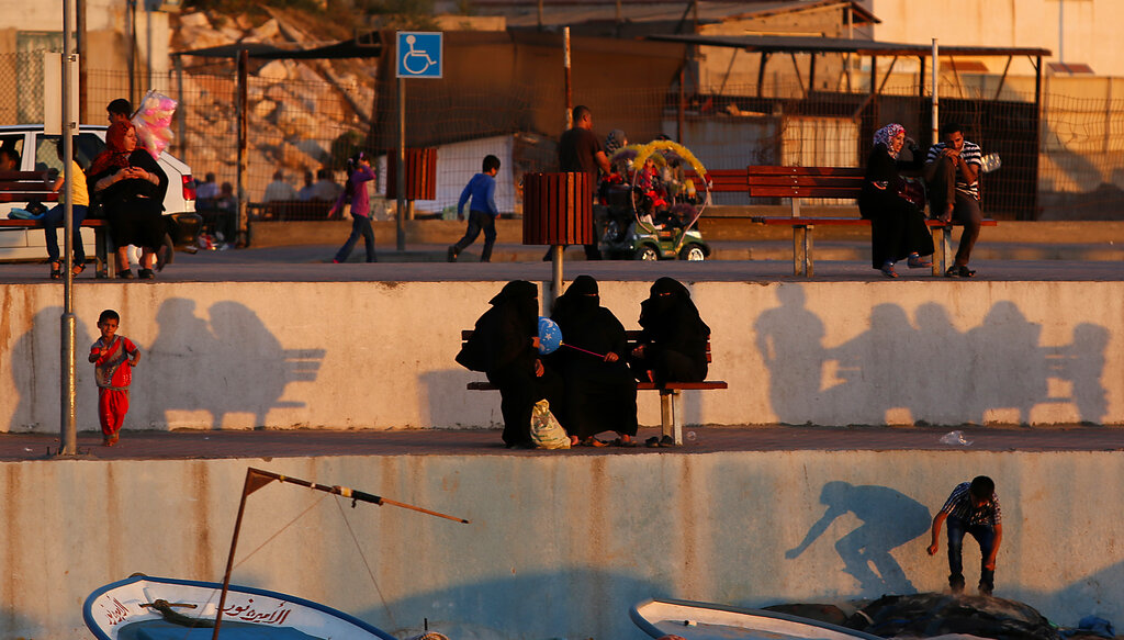 Palestinians sit by the Mediterranean Sea at the port in Gaza City, Sunday, June 22, 2014. The sea and its solo port are the prime summer escape for the 1.8 million residents of the Gaza Strip, which is cut off from the world by the near-total closure of Rafah crossing point, Gaza's main gate to the outside world. (AP Photo/Hatem Moussa )