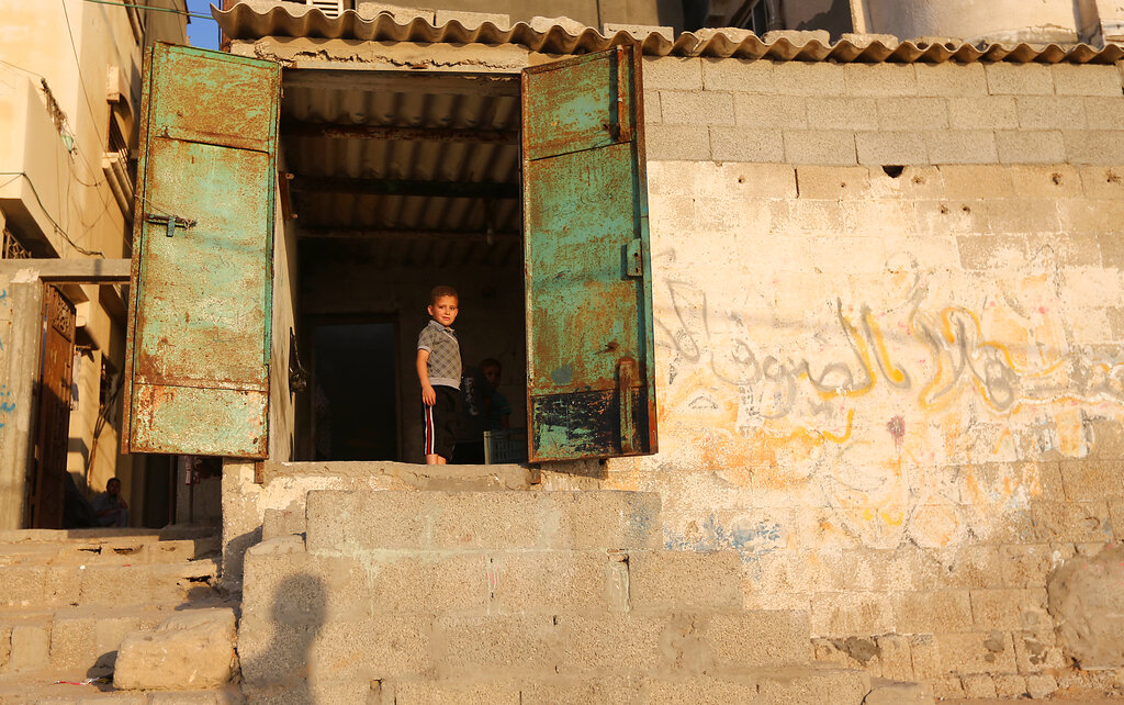 A Palestinian child stands near his house at Shati refugee camp, in Gaza City, Wednesday, June 18, 2014. Al- Shati refugee camp, a Palestinian refugee camp located in the northern Gaza Strip along the Mediterranean Sea coastline in the Gaza Governorate, and more specifically Gaza City. The camp is the third largest refugee camp in the Palestinian Territories. (AP Photo/Hatem Moussa)