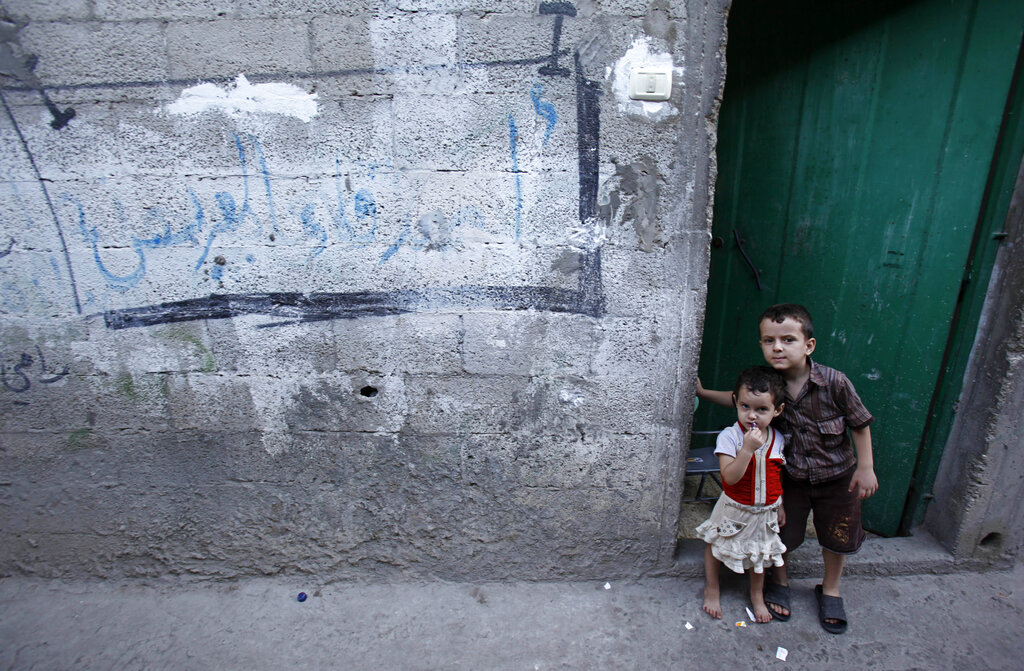 Palestinian children pose at the doorway of their family house in Jabaliya refugee camp in Jabaliya, northern Gaza Strip, Thursday, Sept. 26, 2013. (AP Photo/Adel Hana)