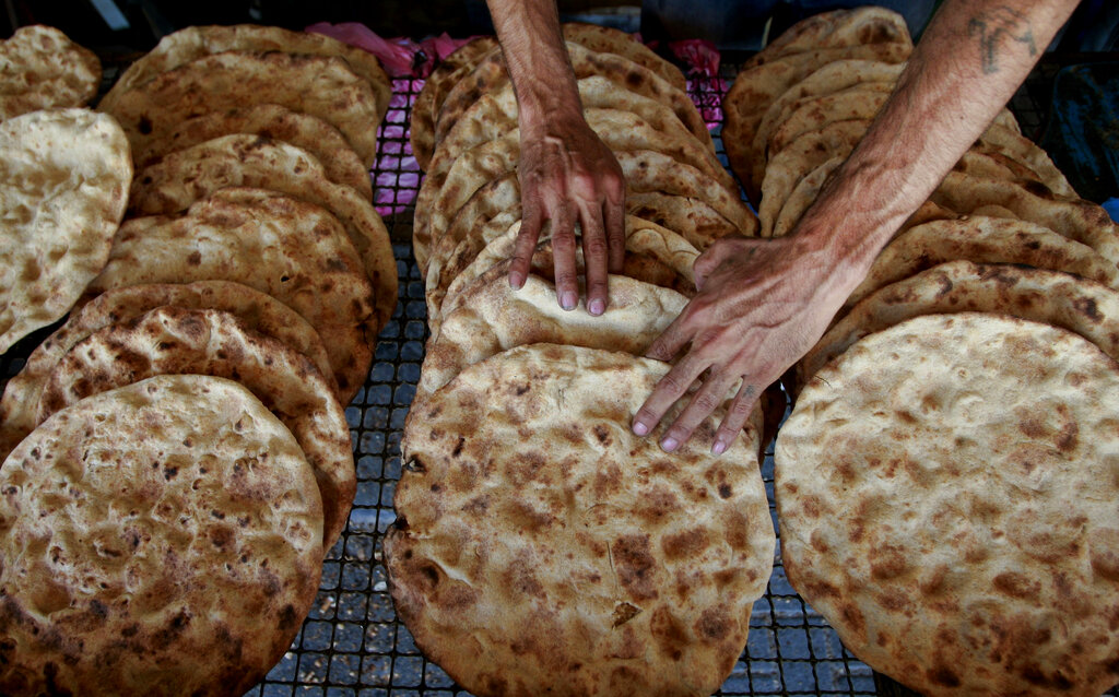 A Palestinian man prepares traditional bread for sale at a popular bakery in the West Bank city of Jenin, Thursday, June 26, 2014. (AP Photo/Mohammed Ballas)