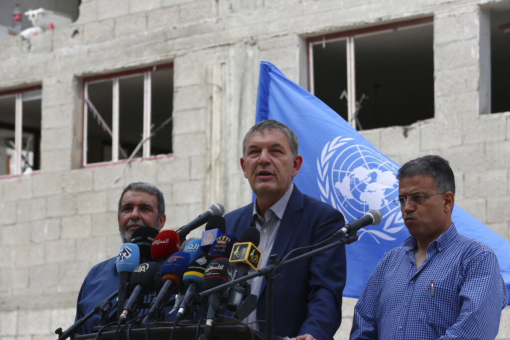 Philippe Lazzarini, center, Commissioner-General of United Nations Relief and Works Agency for Palestine Refugees in the Near East (UNRWA), talks during press conference after his visit to Abu Salmiya family house (background) damaged by the 11-day war between Gaza's Hamas rulers and Israel, at the Balakhiya area in Shati refugee camp, Tuesday, Oct. 12, 2021. (AP Photo/Adel Hana)