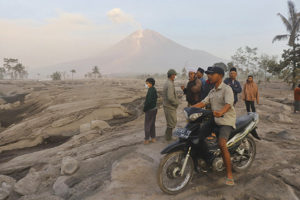 Villagers inspect an area affected by the eruption of Mount Semeru in Kajar Kuning vilage in Lumajang, East Java, Indonesia, Monday, Dec. 5, 2022. Indonesia's highest volcano on its most densely populated island released searing gas clouds and rivers of lava Sunday in its latest eruption. (AP Photo/Imanuel Yoga)