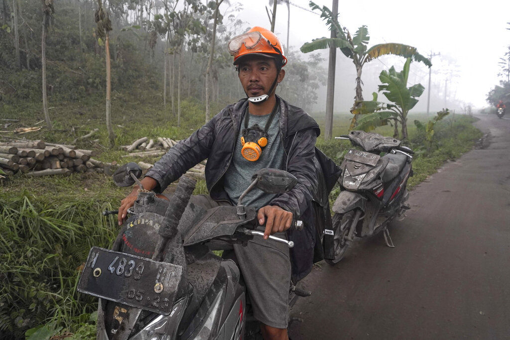 Villagers' motorbikes are seen covered in volcanic ash from the eruption of Mount Semeru in Lumajang, East Java, Indonesia, Monday, Dec. 5, 2022. Improved weather conditions Monday allowed rescuers to resume evacuation efforts and a search for possible victims after the highest volcano on Indonesia's most densely populated island erupted, triggered by monsoon rains. (AP Photo/Dicky Bisinglasi)