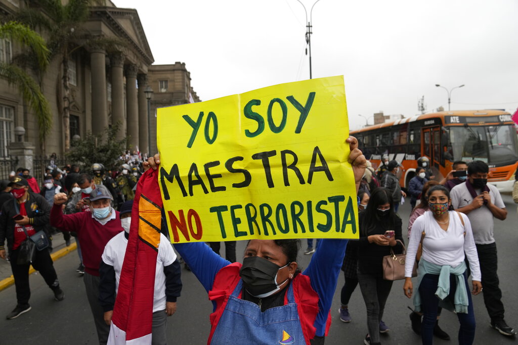FILE - A woman holds up a sign with a message that reads in Spanish; 
