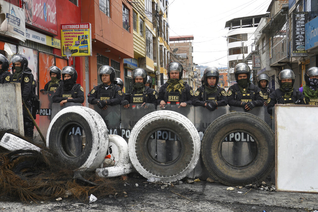 Police stand guard behind a barricade the created, one day after protests against President Dina Boluarte in Andahuaylas Peru, Monday, Dec. 12, 2022. Peru's Congress voted to remove President Pedro Castillo from office Wednesday and replace him with the vice president, Boluarte, shortly after Castillo tried to dissolve the legislature ahead of a scheduled vote to remove him. (AP Photo/Franklin Briceno)