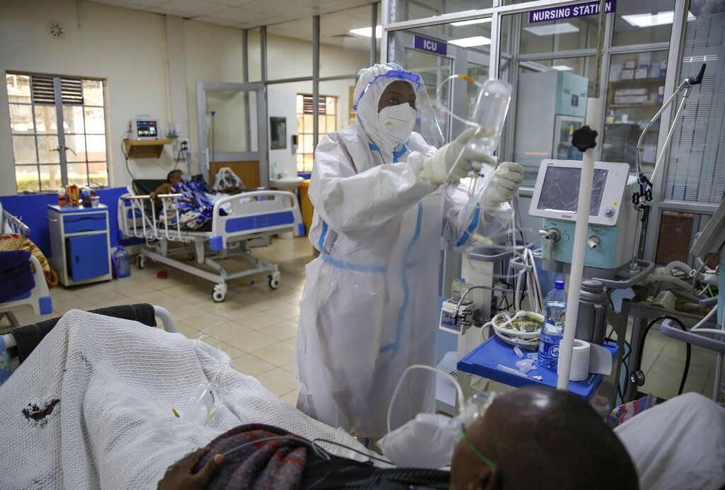 A medical worker attends to a coronavirus patient in the intensive care unit of an isolation and treatment center for those with COVID-19 in Machakos, south of the capital Nairobi, in Kenya Tuesday, Nov. 3, 2020. As Africa is poised to surpass 2 million confirmed coronavirus cases it is Kenya's turn to worry the continent with a second surge in infections well under way. (AP Photo/Brian Inganga)