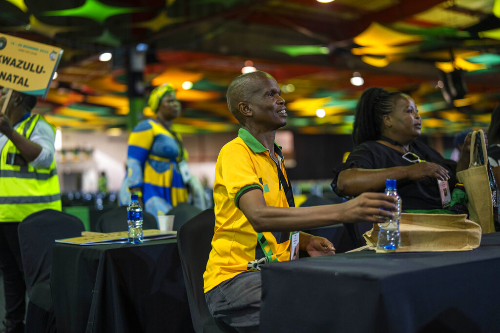 African National Congress delegates wait for the delayed start of the ANC national conference in Johannesburg, South Africa, Friday Dec. 16, 2022. The conference will elect the party's leadership and adopt key policies for governing the country. President Cyril Ramaphosa is seeking re-election as the party's leader at the national conference which is held every five years and is the ANC's highest decision-making body. (AP Photo/Jerome Delay)