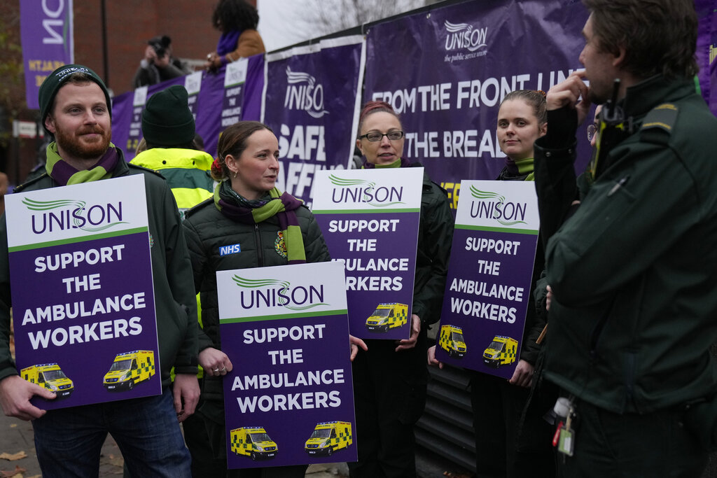 Ambulance workers go on strike and hold placards as they join the picket line outside the Headquarters of the London Ambulance Service in London, Wednesday, Dec. 21, 2022. (AP Photo/Alastair Grant)