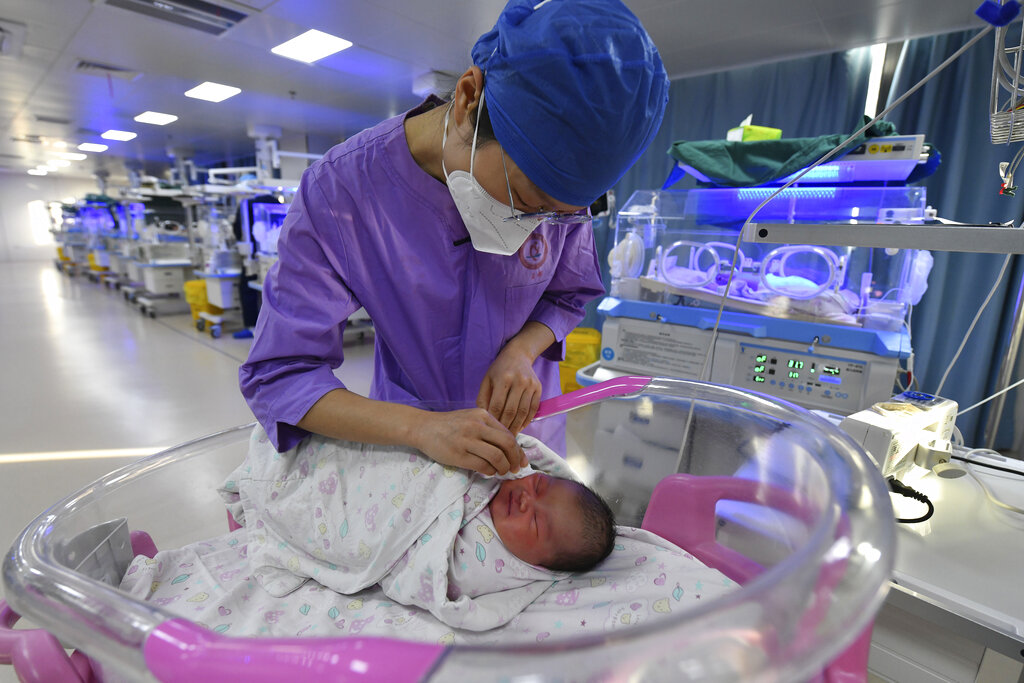 A nurse takes care of a newborn baby in a maternity hospital in Fuyang in central China's Anhui province on Tuesday, Jan. 17, 2023. A population that has crested and is gradually beginning to shrink will pose new challenges for Chinese leaders ranging from persuading seniors to stay in the workforce, to encouraging young people to start families and parents to allow their children to join the military. (Chinatopix via AP)