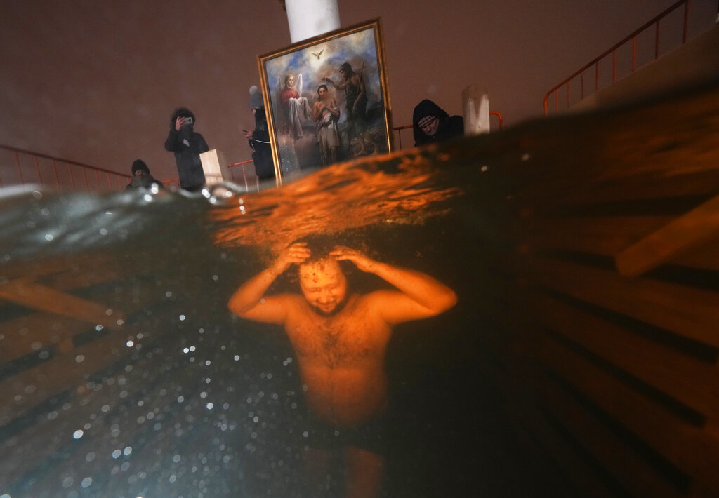 A Russian Orthodox believers dips in the icy water during a traditional Epiphany celebration in St. Petersburg, Russia, Wednesday, Jan. 19, 2022. Thousands of Russian Orthodox Church followers plunged into icy rivers and ponds across the country to mark Epiphany, cleansing themselves with water deemed holy for the day. The temperature in St. Petersburg is -1C (30F). (AP Photo/Dmitri Lovetsky)