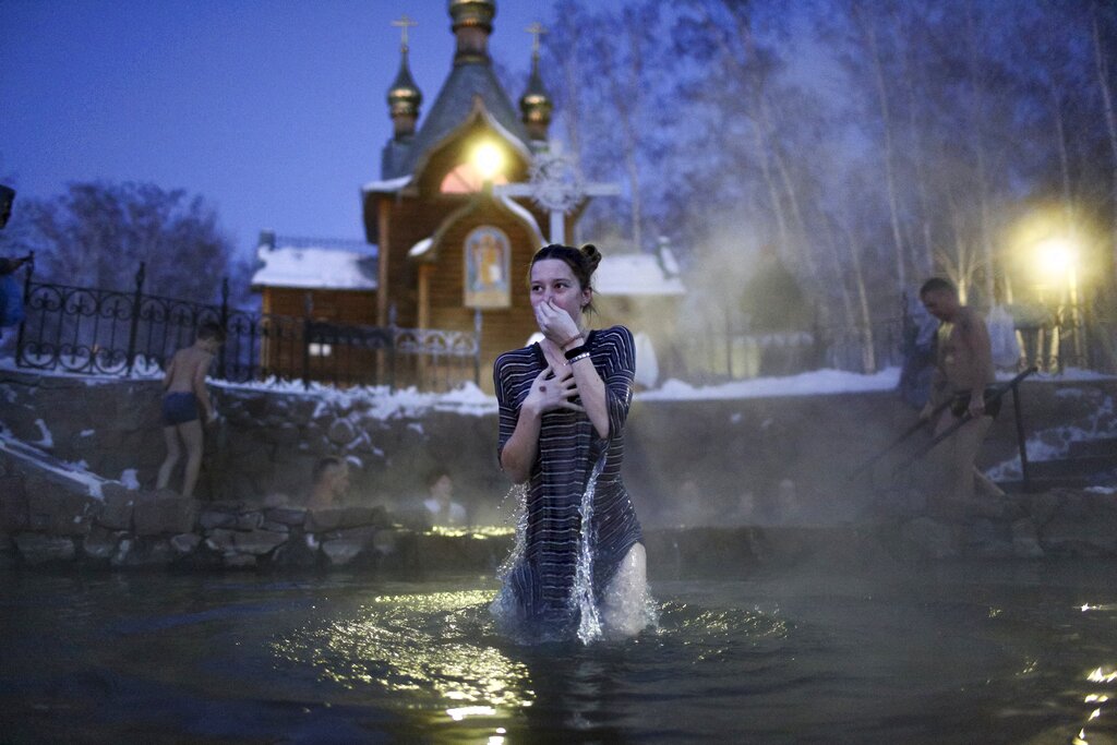 A woman bathes in water during a traditional Epiphany celebration as the temperature dropped to about -12 degrees (10,4 degrees Fahrenheit) near the Achairsky monastery outside the Siberian city of Omsk, Russia, early Thursday, Jan. 19, 2023. Across Russia, the devout and the daring are observing the Orthodox Christian feast day of Epiphany by immersing themselves in frigid water through holes cut through the ice of lakes and rivers. Epiphany celebrates the revelation of Jesus Christ as the incarnation of God through his baptism in the River Jordan. (AP Photo/Evgeniy Sofiychuk)