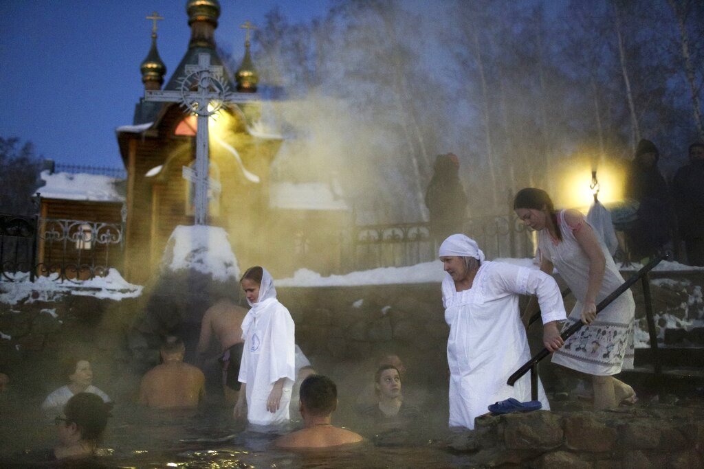 People bath in water during a traditional Epiphany celebration as the temperature dropped to about -12 degrees (10,4 degrees Fahrenheit) near the Achairsky monastery outside the Siberian city of Omsk, Russia, early Thursday, Jan. 19, 2023. Across Russia, the devout and the daring are observing the Orthodox Christian feast day of Epiphany by immersing themselves in frigid water through holes cut through the ice of lakes and rivers. Epiphany celebrates the revelation of Jesus Christ as the incarnation of God through his baptism in the River Jordan. (AP Photo/Evgeniy Sofiychuk)