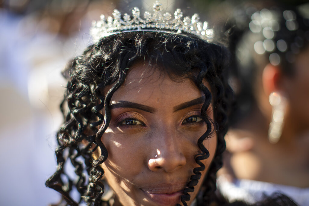 A bride poses for a photo as she participates in a mass wedding event in Managua, Nicaragua, Tuesday, Feb 14, 2023. (AP Photo/Inti Ocon)